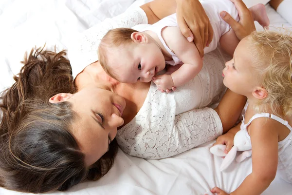 Mother and children together in bed — Stock Photo, Image