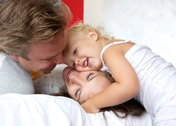 Madre y padre cariñosos sonriendo con un niño pequeño — Foto de Stock
