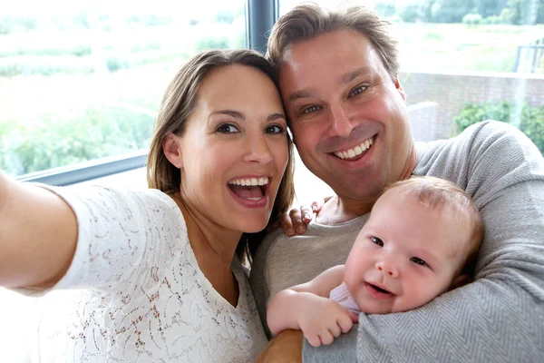 Happy couple taking a selfie with baby — Stock Photo, Image