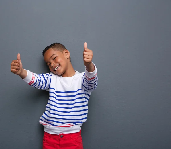 Söt liten pojke leende med tummen upp tecken — Stockfoto