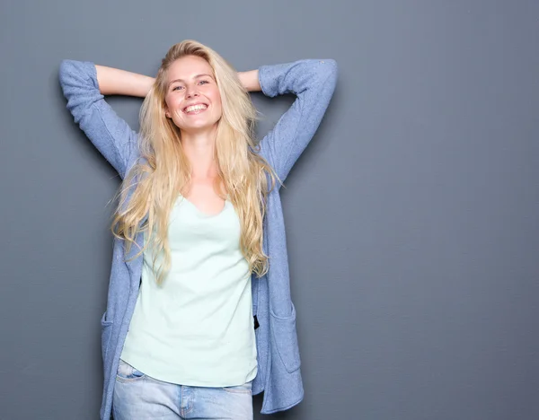 Junge Frau entspannt sich mit den Händen hinter dem Kopf — Stockfoto