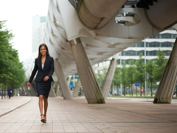 Jovem mulher de negócios andando na calçada — Fotografia de Stock