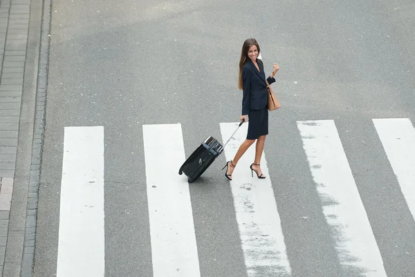 Mujer de negocios cruzando la calle con bolsas de viaje —  Fotos de Stock