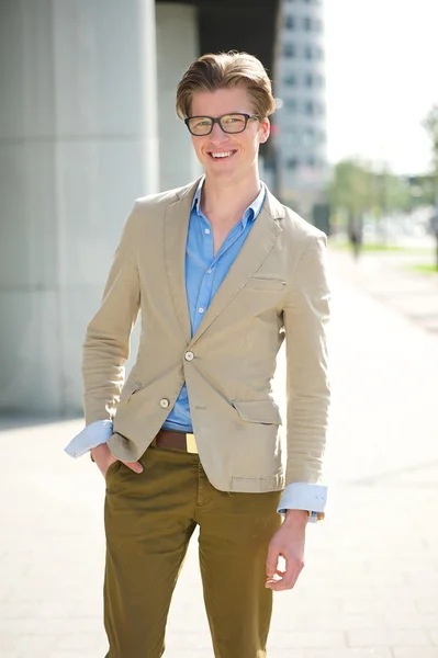Junger Mann mit Brille lächelt draußen — Stockfoto