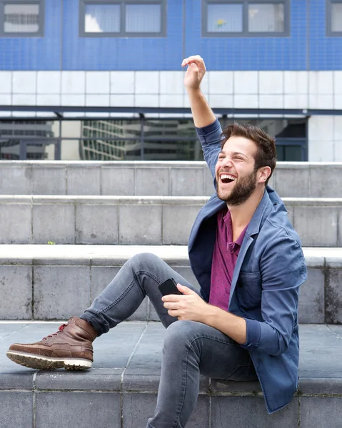 Cheerful young man holding mobile phone — Stock Photo, Image