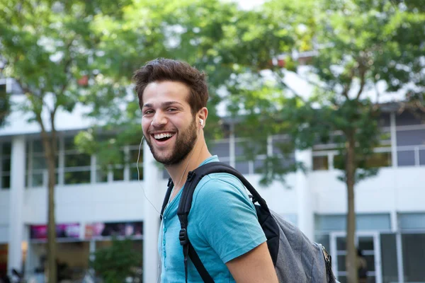 Junger Mann lächelt mit Rucksack — Stockfoto