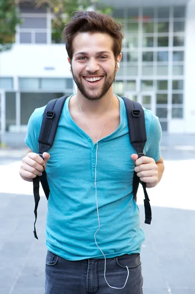 Glücklicher junger Mann geht mit Tasche ins Freie — Stockfoto