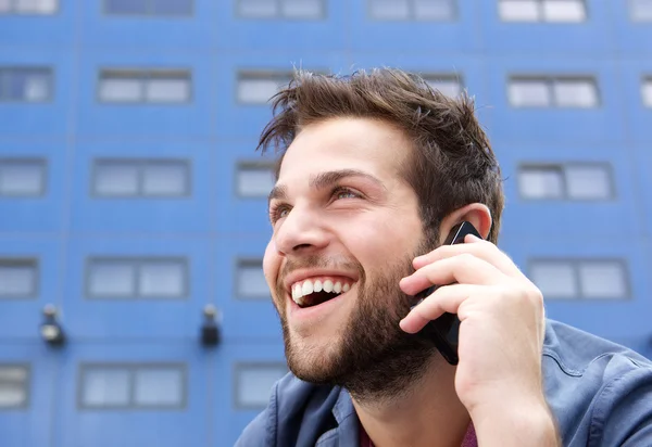 Happy young man talking on mobile phone — Stock Photo, Image