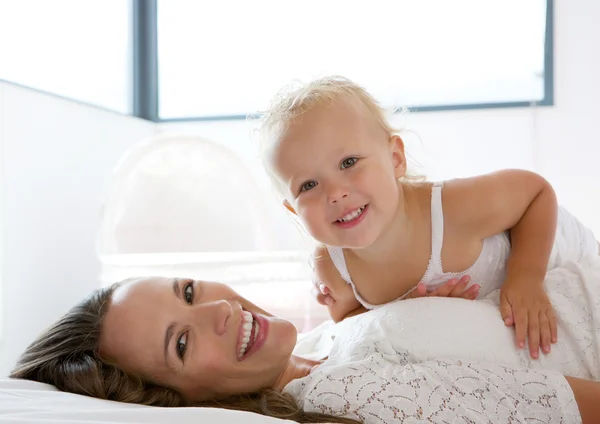 Glückliche Mutter lächelt mit süßem kleinen Mädchen — Stockfoto