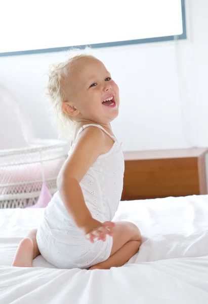 Mädchen lacht und spielt im Bett — Stockfoto