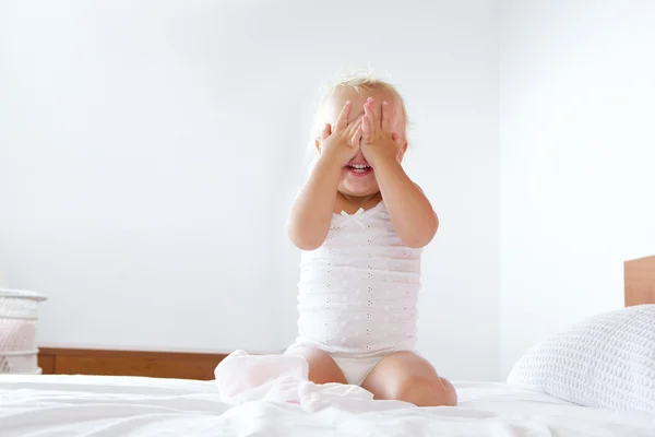 Nettes kleines Mädchen versteckt sich mit Händen, die das Gesicht verdecken — Stockfoto