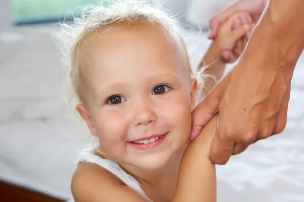 Lächelndes kleines Mädchen hält Mutter an den Händen — Stockfoto