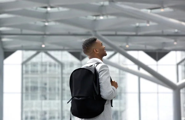 Joven sonriendo con la bolsa en el aeropuerto — Foto de Stock