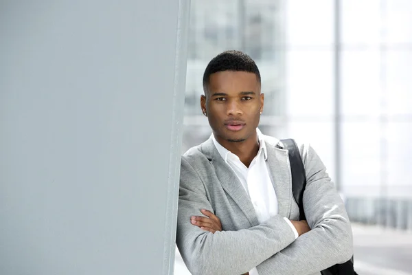 Schöner junger Mann posiert mit Tasche am Flughafen — Stockfoto