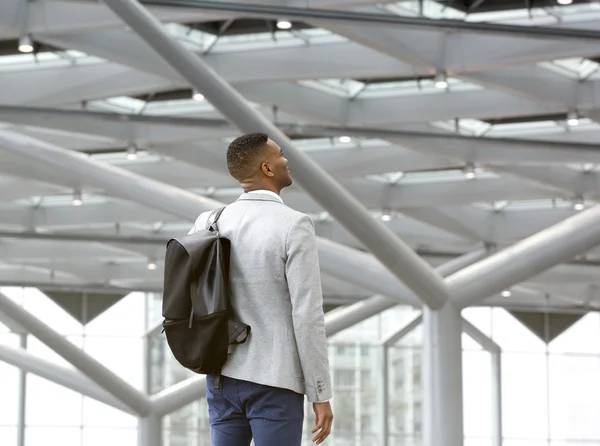 Svart man står ensam i flygplats med väska — Stockfoto