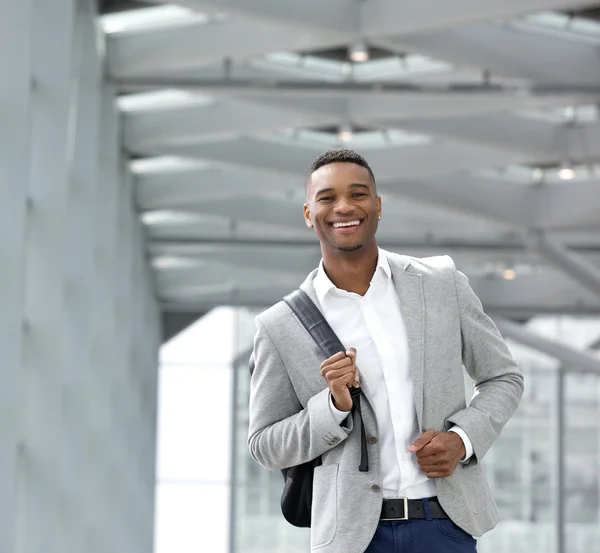 Cheerful young man walking at airport with bag Royalty Free Stock Images
