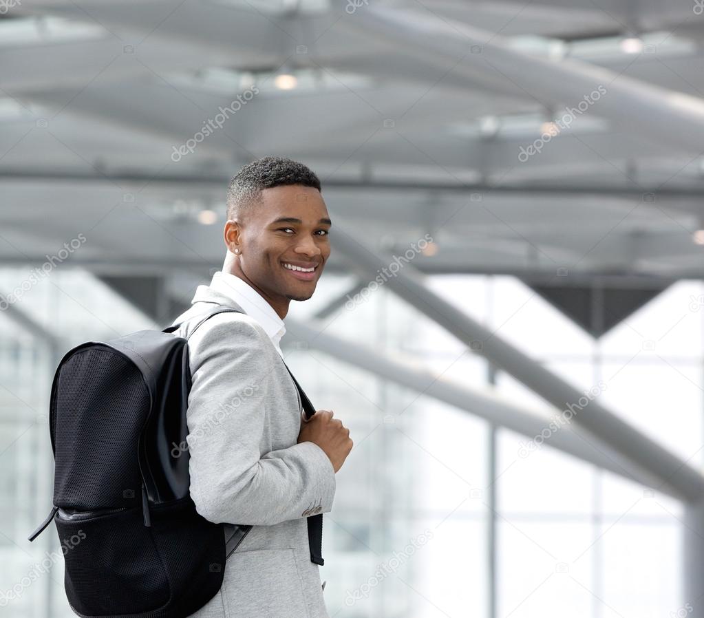 Handsome young black man smiling with bag