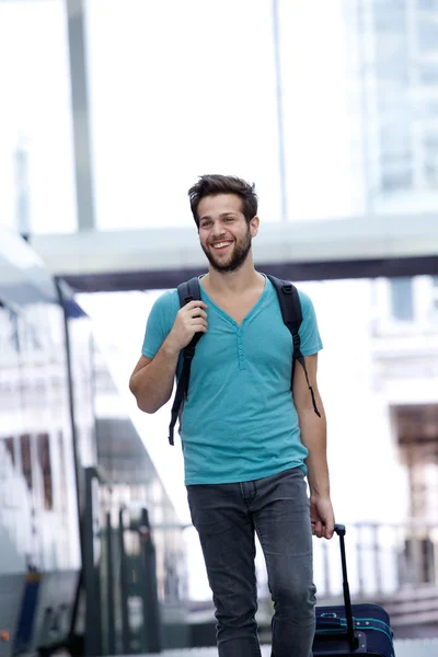 Lächelnder Mann läuft mit Taschen am Bahnhof — Stockfoto