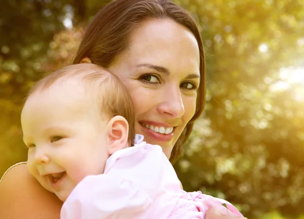 Lyckliga modern anläggning leende baby — Stockfoto