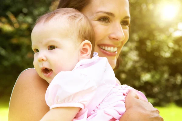 Sorrindo mãe segurando bebê bonito — Fotografia de Stock