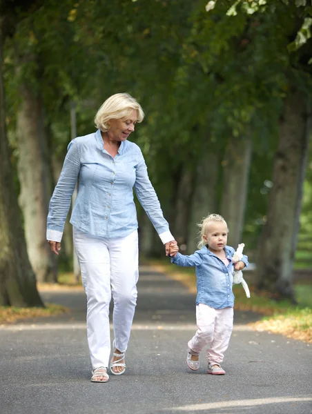 Бабушка гуляет с маленькой девочкой в парке — стоковое фото