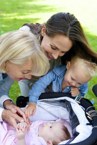 Mor och mormor leende på baby — Stockfoto