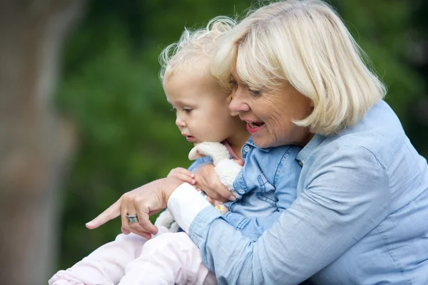 Grootmoeder meisje van de baby te houden en wijzen — Stockfoto