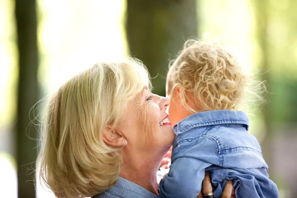 Gelukkig grootmoeder knuffelen weinig meisje van de baby — Stockfoto
