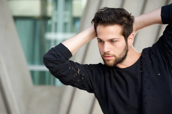 Handsome male fashion model posing with hands behind head — Stock Photo, Image