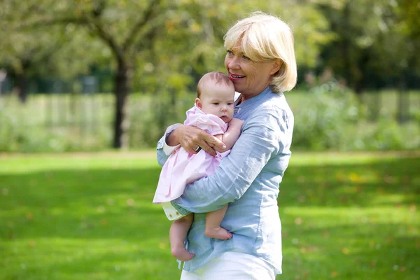 Grandmother holding baby granddaughter — Stock Photo, Image