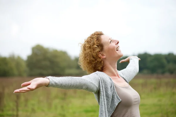 Vrolijke zorgeloos vrouw met uitgestrekte armen — Stockfoto