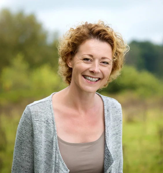 Mooie volwassen vrouw die lacht in het park — Stockfoto