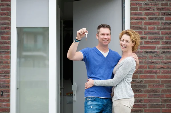 Szczęśliwa para uśmiechający się poza nowego domu — Zdjęcie stockowe