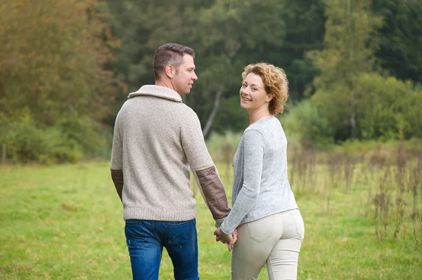 Pareja feliz caminando por el campo — Foto de Stock