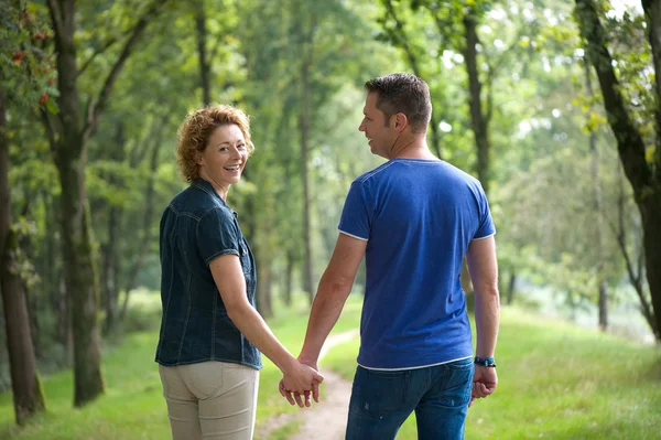 Paar geht ins Freie und hält Händchen — Stockfoto