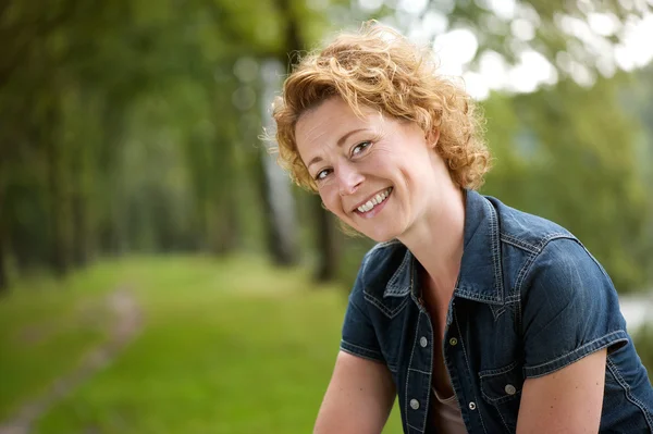 Atrakcyjna kobieta uśmiechając się na zewnątrz w lesie — Zdjęcie stockowe