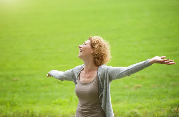 Vrouw genieten van het buitenleven met armen verspreid open — Stockfoto