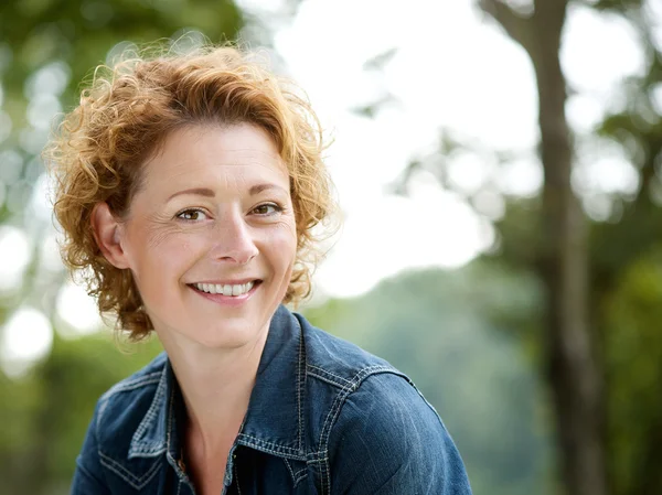 Cheerful older woman smiling outdoors Stock Photo