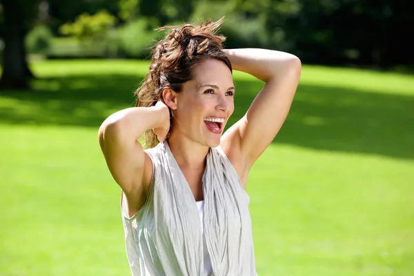 Mulher feliz rindo com as mãos no cabelo — Fotografia de Stock