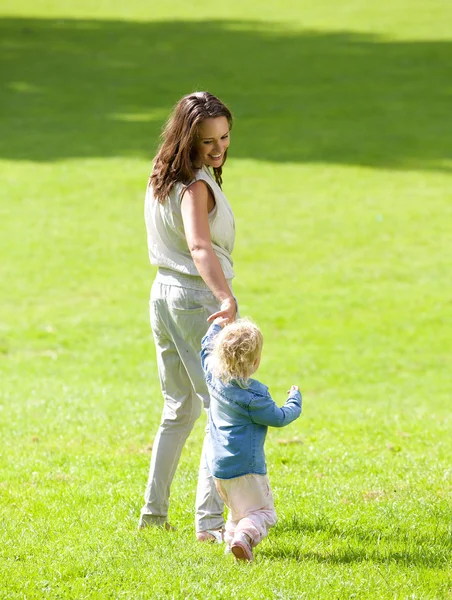 Matka a dítě dívka chůze na trávě — Stock fotografie