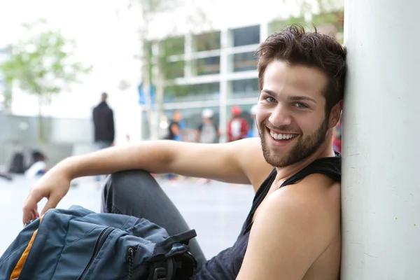 Cooler Typ, der draußen mit Tasche sitzt — Stockfoto