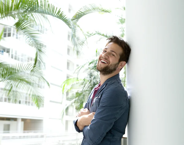 Smiling man leaning with arms crossed inside building — Stock Photo, Image