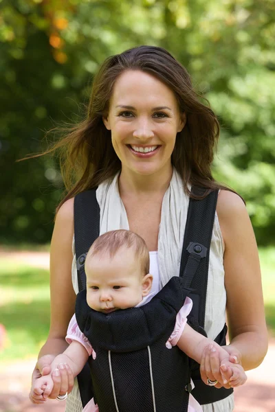 Açık havada yürüyüş bebek ile annesi gülümseyerek — Stok fotoğraf