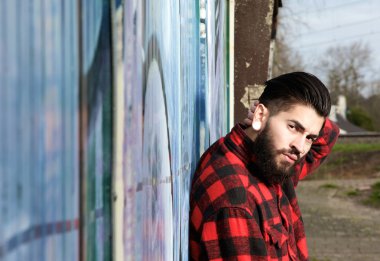 Latin adam sakal ve açık havada oturup piercings