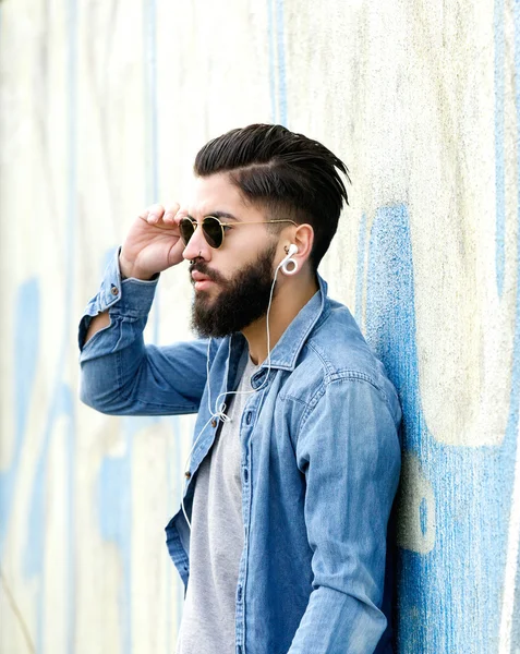 Красавчик с бородой слушает музыку в наушниках — стоковое фото