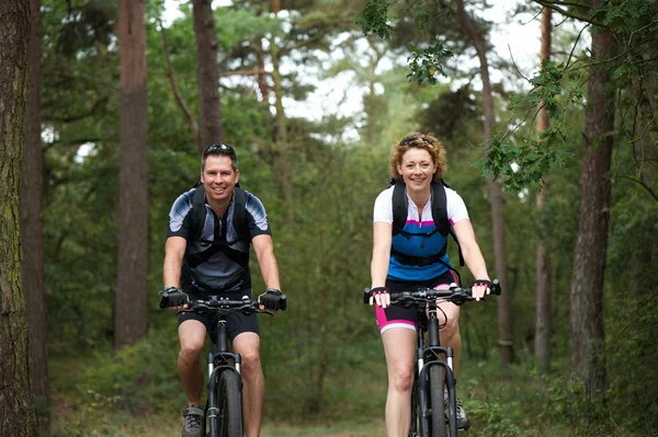 Casal desfrutando de um passeio de bicicleta na natureza — Fotografia de Stock