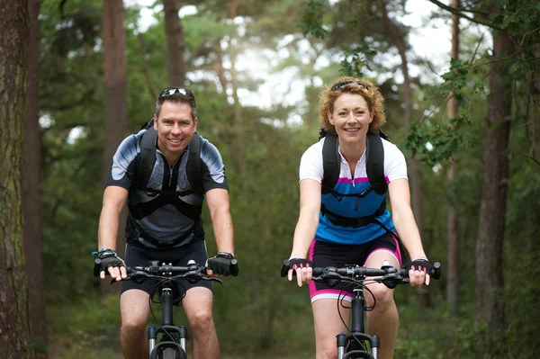 Man en vrouw fietser glimlachend buitenshuis — Stockfoto