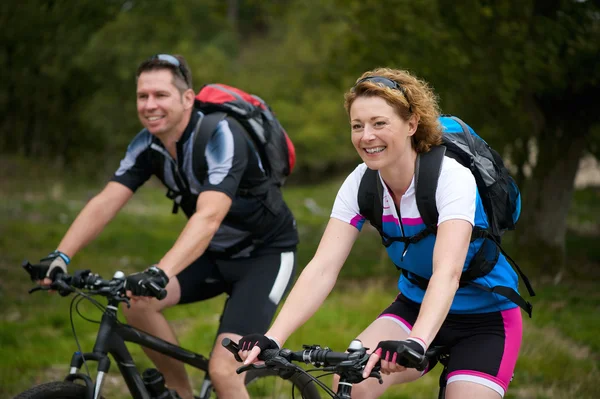 Man and woman enjoying a bike ride in nature — Stock Photo, Image