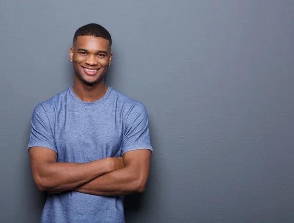 Sorrindo homem negro posando com os braços cruzados — Fotografia de Stock