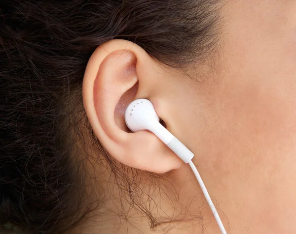 Νεαρή γυναίκα αυτί με το ακουστικό — Φωτογραφία Αρχείου